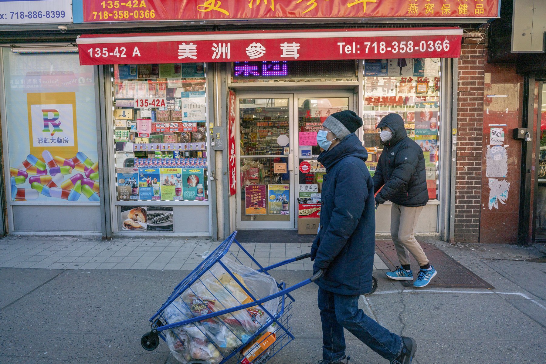 Clients of the La Jornada pantry in Flushing, Queens bring food home on Roosevelt Ave.