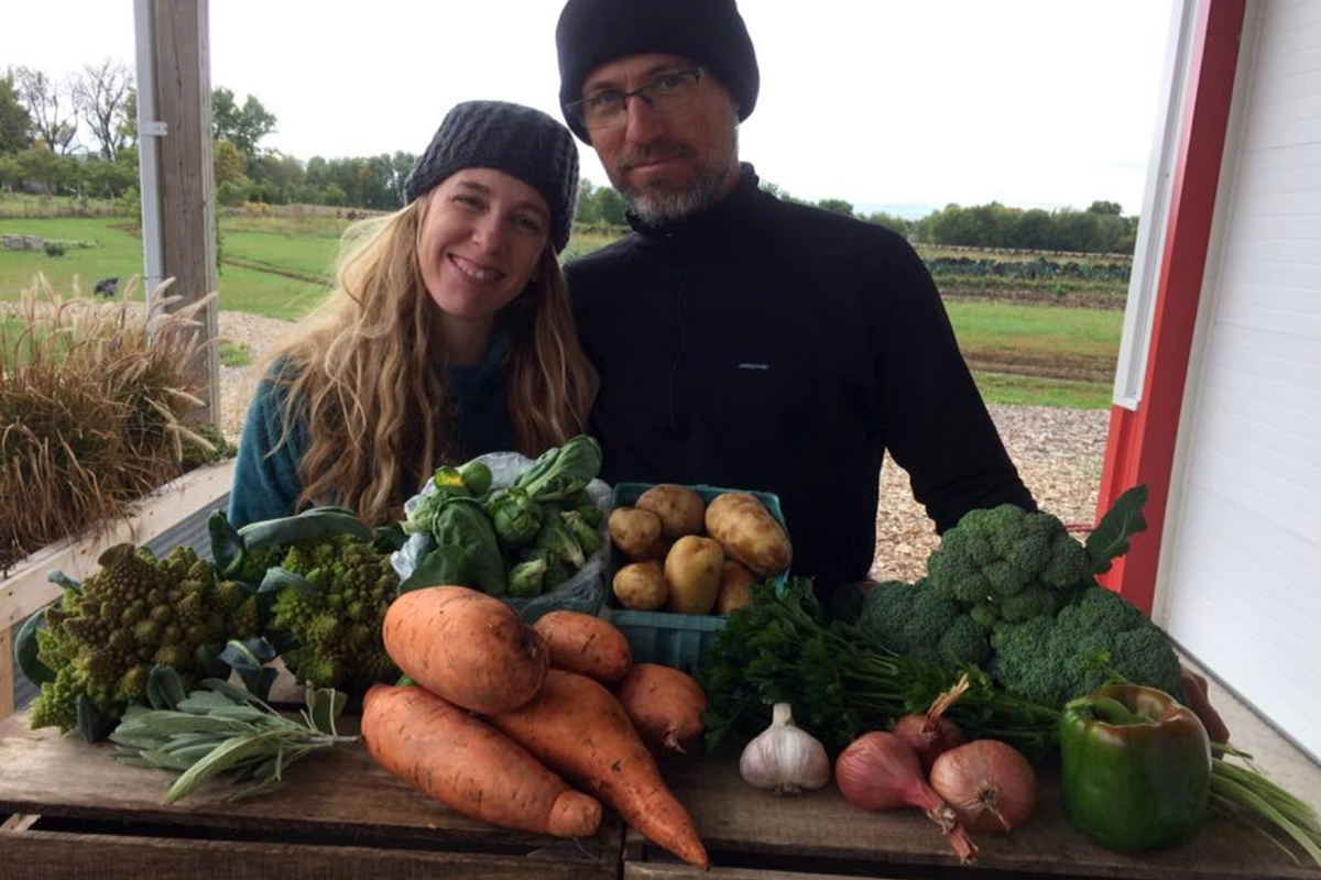 Melissa and Andy Dunham with a weekly CSA share from their farm. (Photo courtesy of Grinnell Heritage Farm)