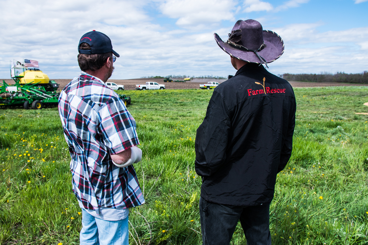 A Farm Rescue volunteer stands with a farmer getting help from the nonprofit.