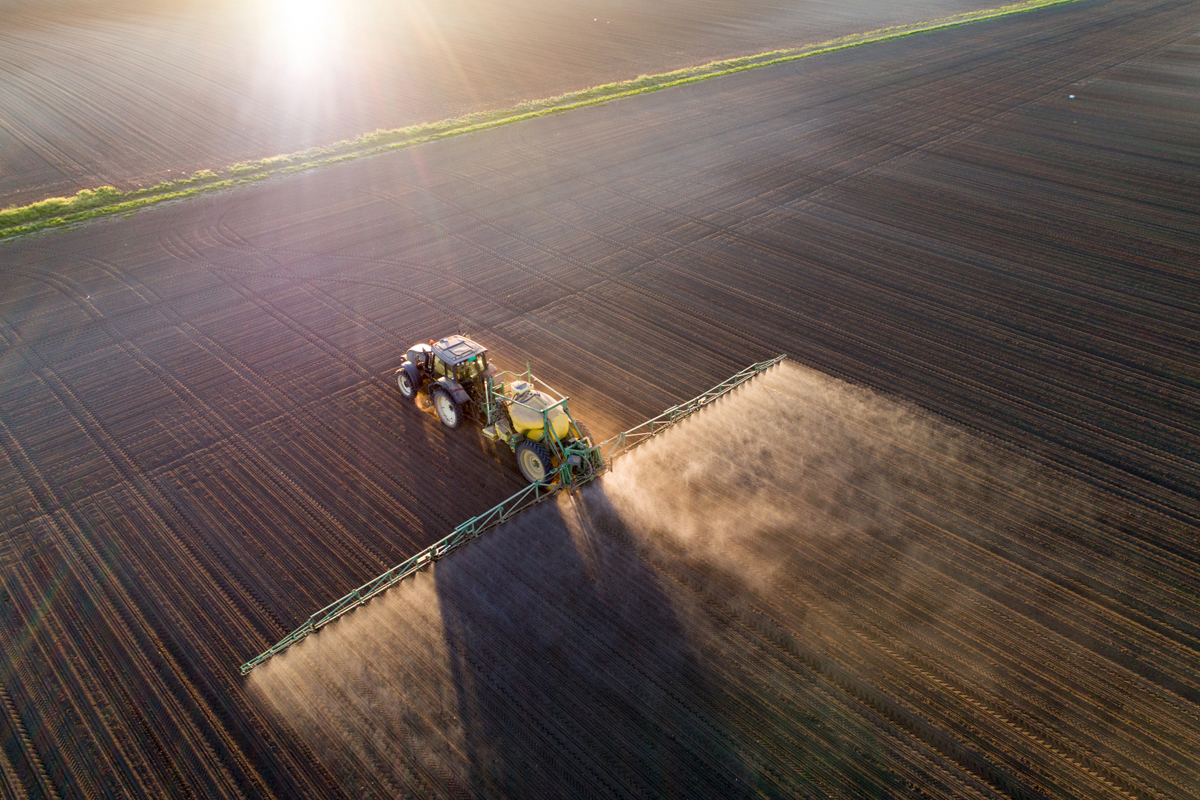 tractor spraying nitrogen fertilzer on a farm field