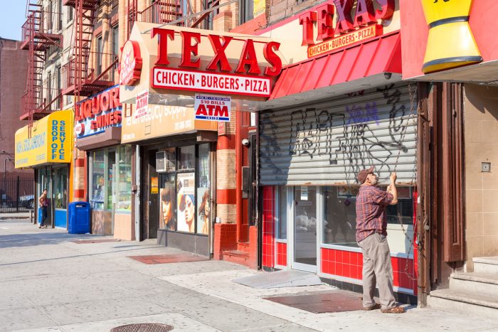 a street in harlem with fast food and liquor stores