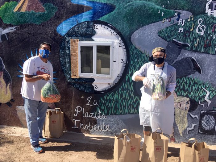 Farmers Russell and Siddiq, from the indigenous-led La Plazita Institute, prepare organic carrots and asparagus to deliver to the Farm to Foodbank initiative. (Photo courtesy of the American Friends Service Commitee New Mexico.)