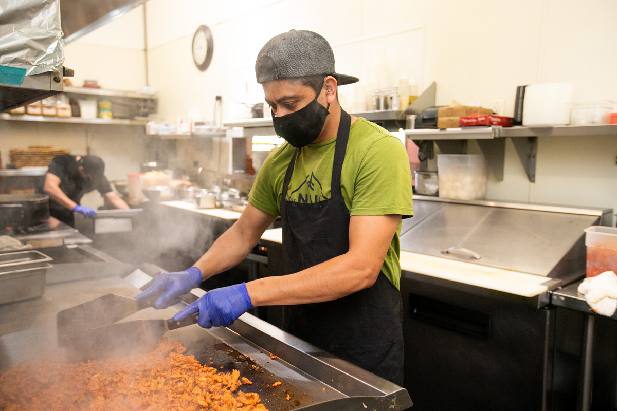 A man cooks food in a restaurant kitchen. Photo credit: One Fair Wage.