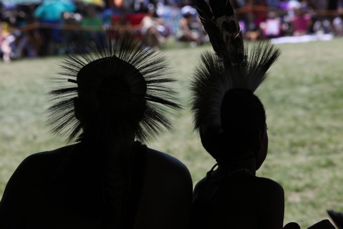 Two Mashpee Wampanoag tribal members in silhouette at a tribal gathering. (Photo courtesy of the Mashpee Wampanoag)