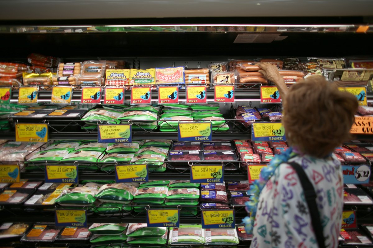 shopper inspecting certified meats for their humanewashing labels