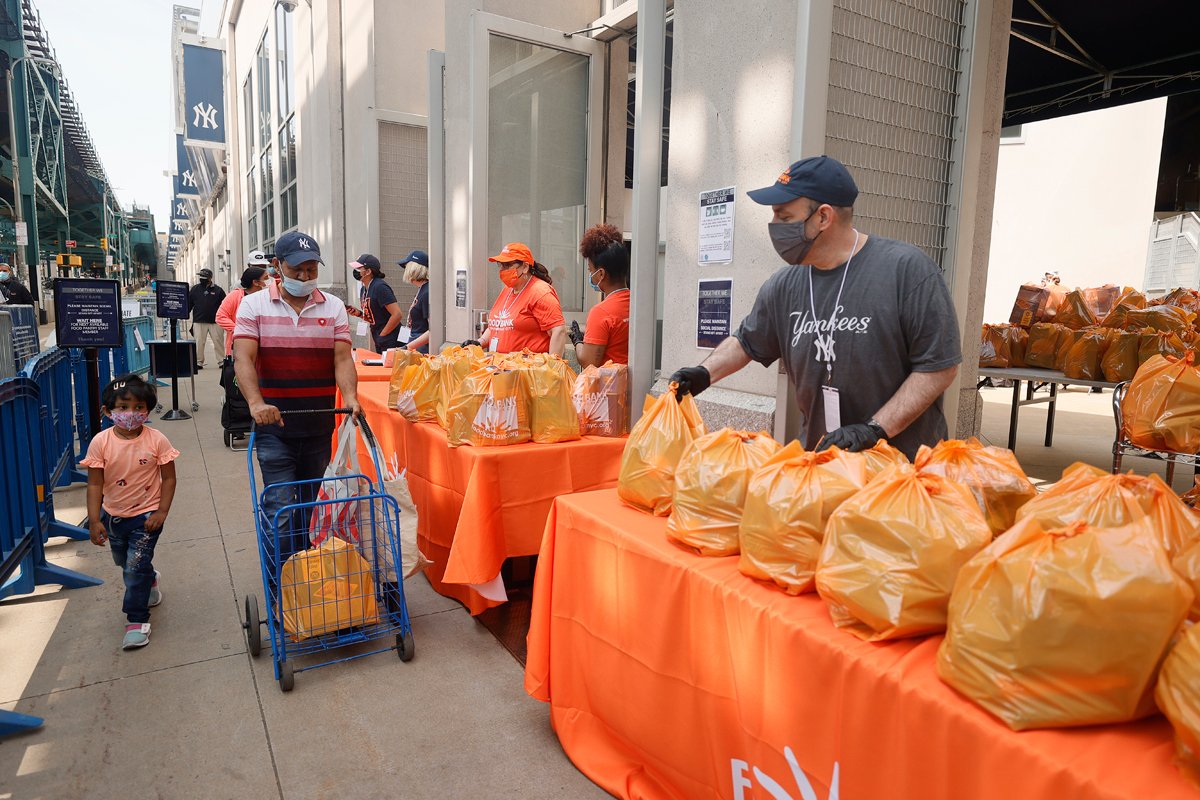 A young child watches as local residents receive food items as Food Bank For New York City teams up with the New York Yankees to kick-off monthly food distribution for New Yorkers in need at Yankee Stadium on May 20, 2021 in New York City.