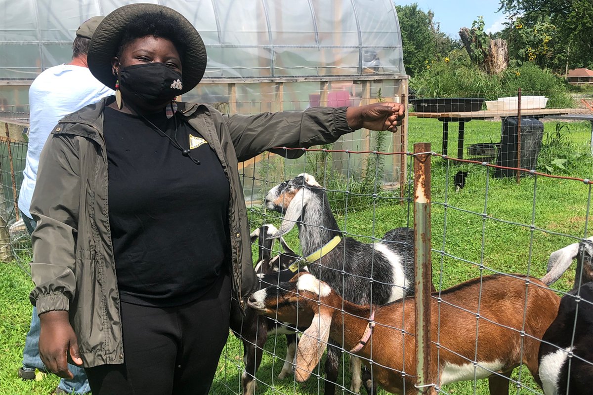 Tosha Phonix stands outside the goat pen.