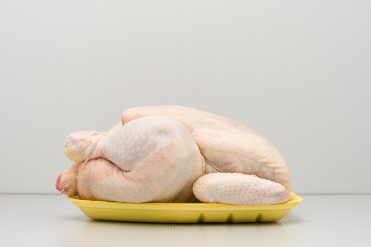 A raw whole chicken on a tray to illustrate the risks of salmonella in chicken